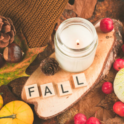 Fall arrangement with pumpkins, apples, pinecones, leaves, and a candle